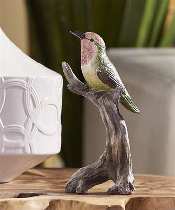 resin bird sitting on a branch with a pink face